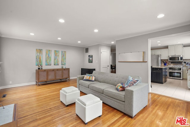 living room with crown molding and light hardwood / wood-style floors