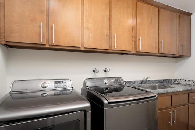 laundry room featuring cabinets, sink, and washing machine and clothes dryer