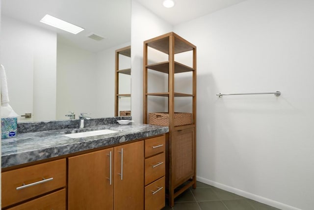 bathroom with vanity, a skylight, and tile patterned flooring