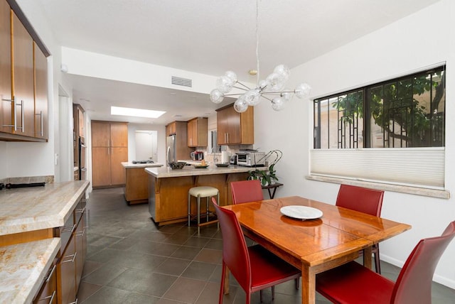 dining space with dark tile patterned floors and a notable chandelier