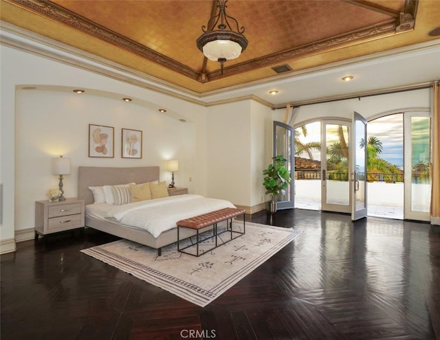 bedroom featuring lofted ceiling, ornamental molding, access to exterior, a tray ceiling, and french doors