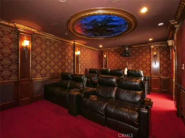 home theater room with a raised ceiling, ornamental molding, and carpet flooring