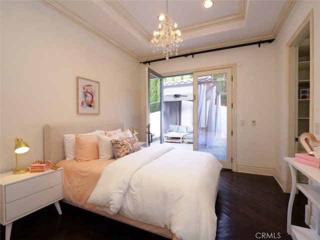 bedroom with a chandelier, dark hardwood / wood-style flooring, access to exterior, a tray ceiling, and crown molding