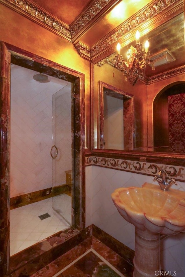 bathroom featuring tile patterned flooring, sink, tile walls, and a chandelier