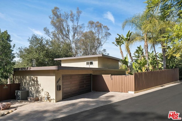 view of front of house with a garage and central AC unit