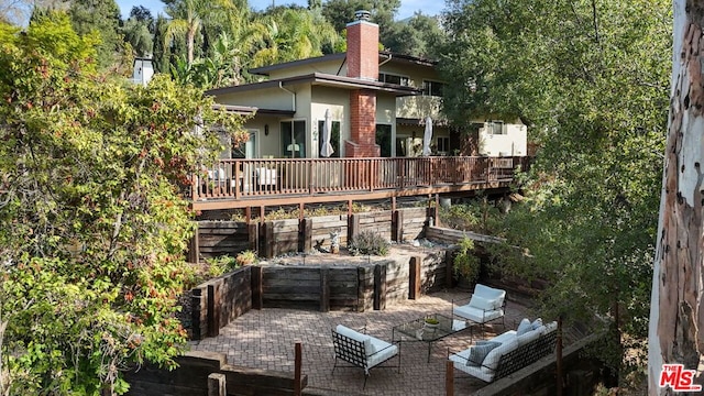 back of property with a wooden deck, outdoor lounge area, and a patio area