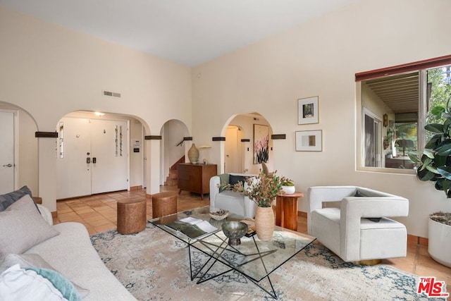 tiled living room with a high ceiling