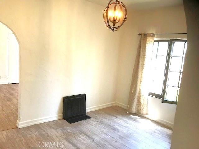 unfurnished room with wood-type flooring and a chandelier