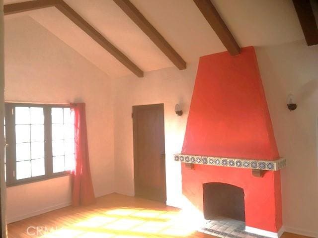 empty room featuring vaulted ceiling with beams