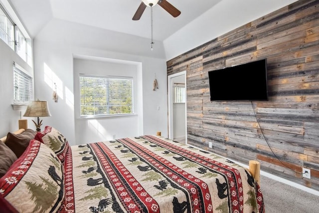 carpeted bedroom featuring ceiling fan and wooden walls