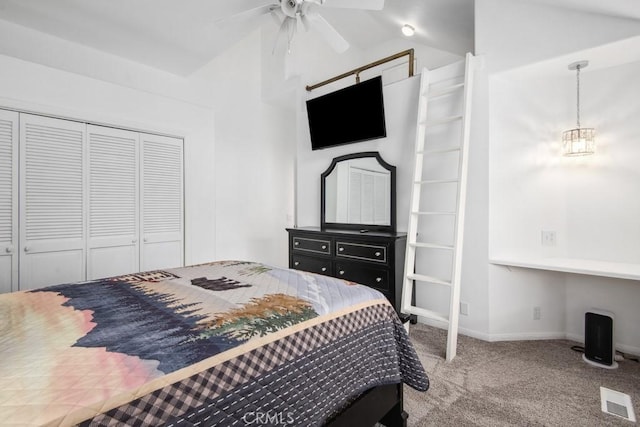 carpeted bedroom featuring lofted ceiling, built in desk, and a closet