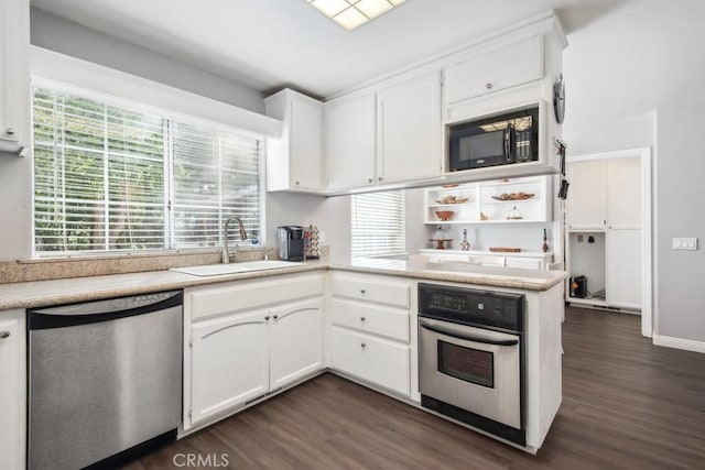 kitchen featuring dark wood-type flooring, sink, kitchen peninsula, stainless steel appliances, and white cabinets