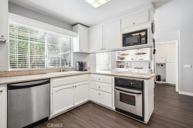 kitchen with sink, white cabinetry, stainless steel appliances, dark hardwood / wood-style flooring, and kitchen peninsula