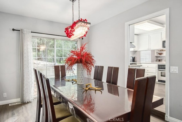 dining area featuring light hardwood / wood-style floors and a chandelier