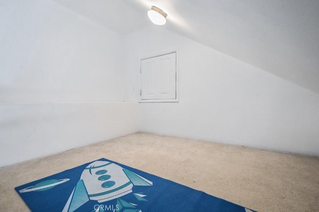 additional living space featuring vaulted ceiling and carpet