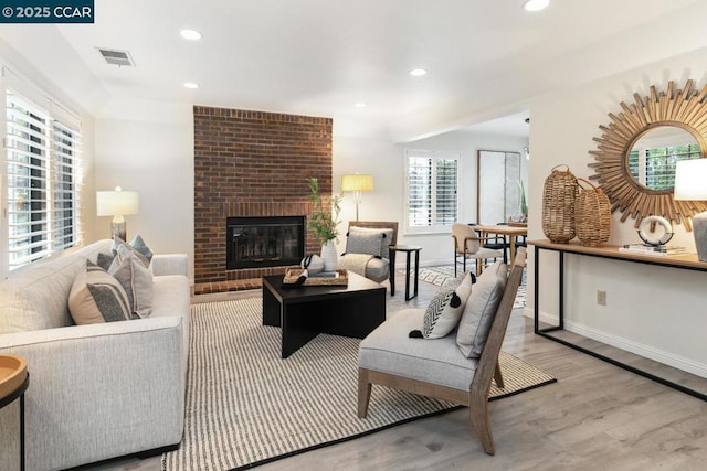 living room featuring a fireplace and light wood-type flooring