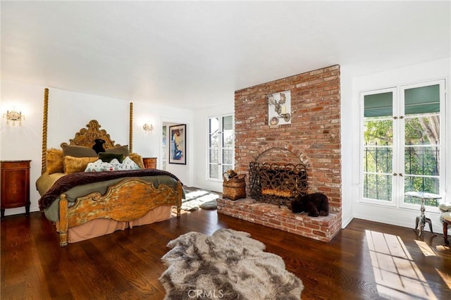 bedroom featuring a brick fireplace and hardwood / wood-style floors