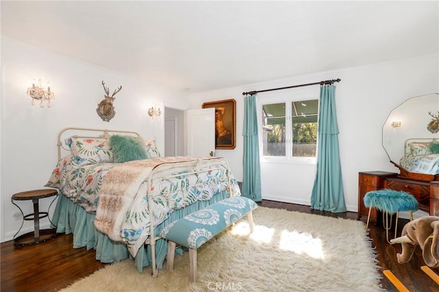 bedroom with dark hardwood / wood-style floors