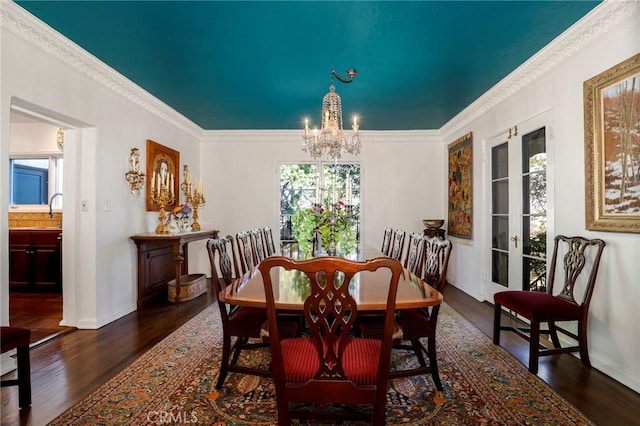 dining area featuring crown molding, dark hardwood / wood-style floors, sink, and a chandelier