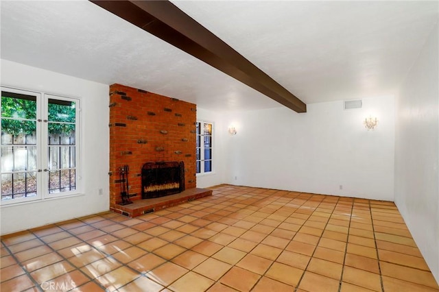 unfurnished living room featuring beamed ceiling, light tile patterned floors, and a fireplace