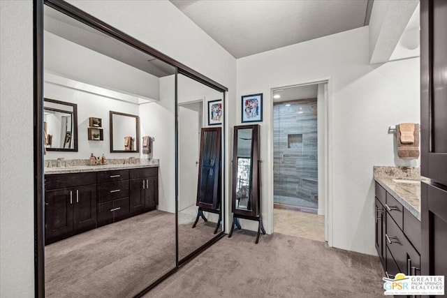 bathroom with vanity and a tile shower