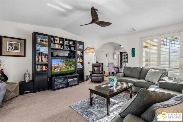 living room with ceiling fan, carpet flooring, and vaulted ceiling