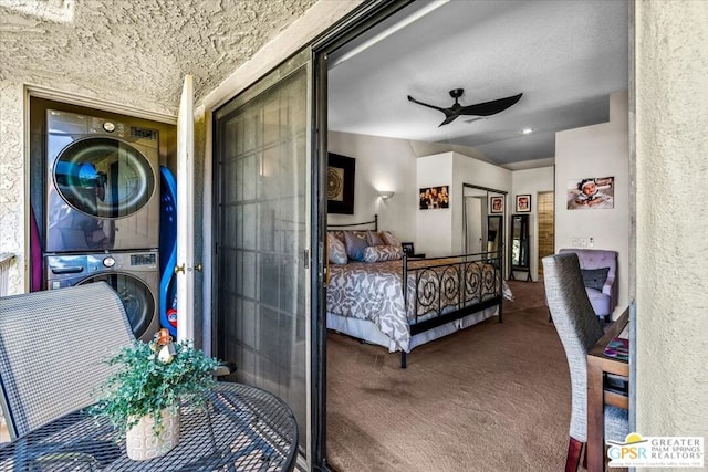 bedroom featuring stacked washer / dryer, carpet flooring, and ceiling fan