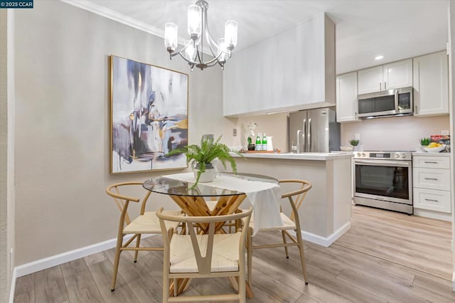 kitchen featuring decorative light fixtures, a chandelier, appliances with stainless steel finishes, light hardwood / wood-style floors, and white cabinets