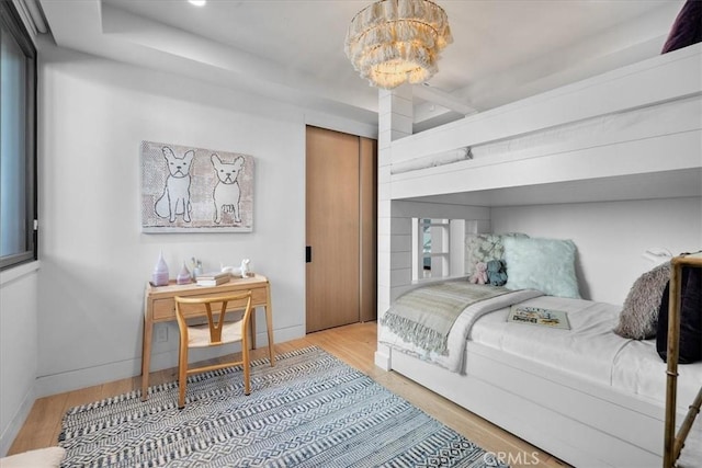 bedroom with an inviting chandelier and hardwood / wood-style floors