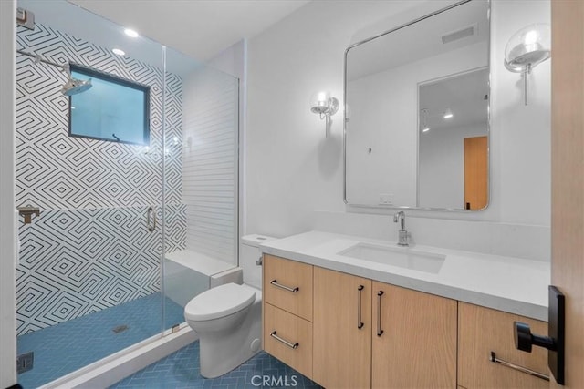 bathroom with vanity, toilet, and a tile shower