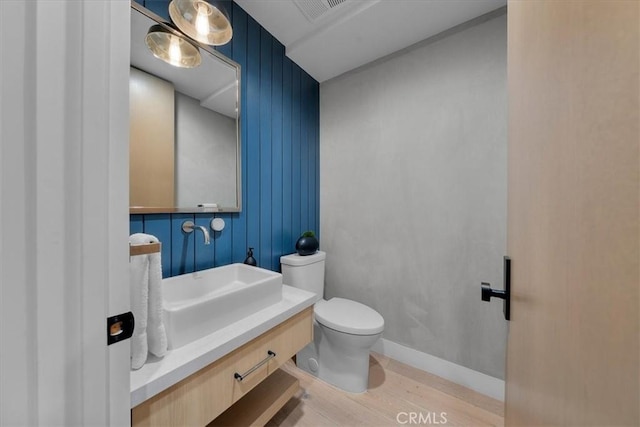 bathroom featuring vanity, wood-type flooring, and toilet