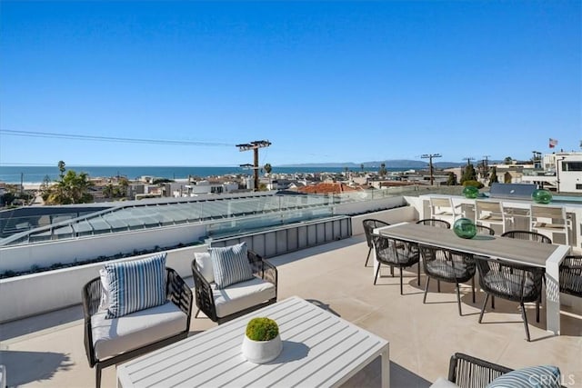 view of patio with area for grilling, a water view, and outdoor lounge area