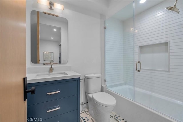 full bathroom featuring vanity, bath / shower combo with glass door, and toilet