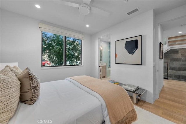 bedroom featuring connected bathroom, light hardwood / wood-style floors, and ceiling fan