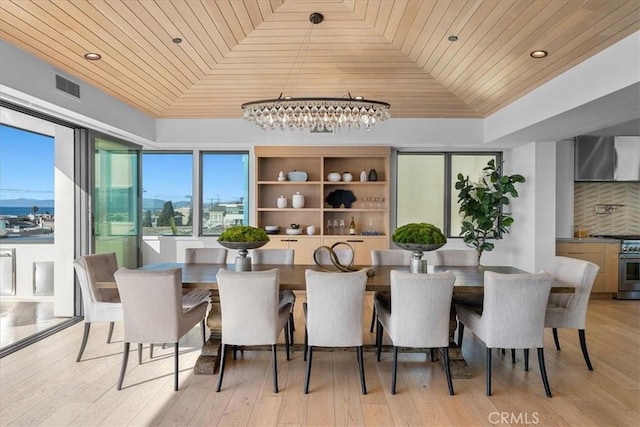 dining area with vaulted ceiling, light wood-type flooring, wood ceiling, and a tray ceiling