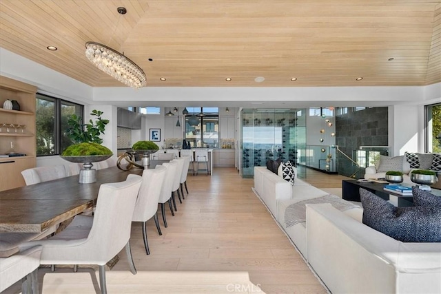 dining area featuring wood ceiling, a fireplace, and light hardwood / wood-style floors