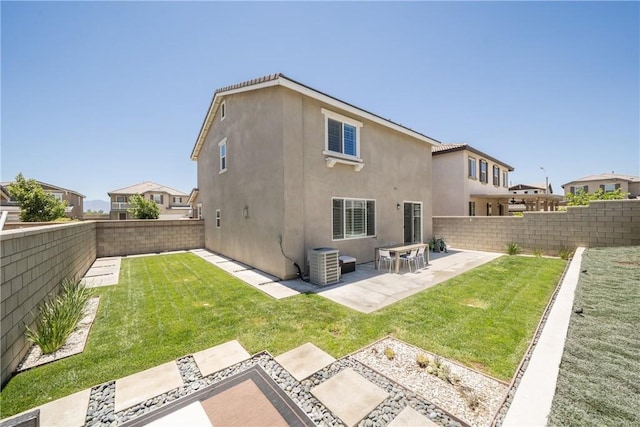 rear view of house with a patio, central AC, and a lawn