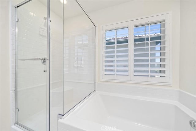 bathroom featuring separate shower and tub