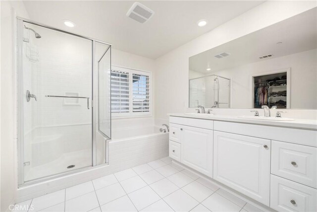 bathroom with tile patterned floors, independent shower and bath, and vanity