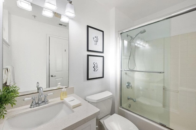 full bathroom featuring vanity, toilet, and combined bath / shower with glass door