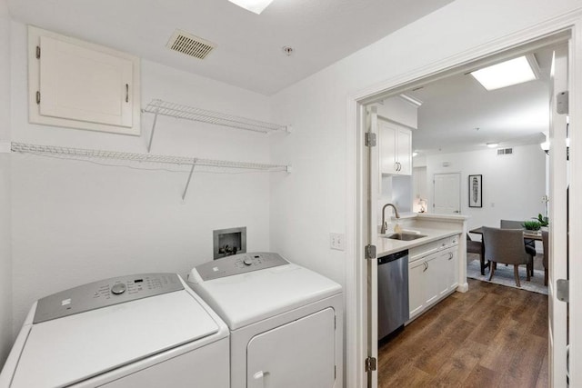 clothes washing area featuring separate washer and dryer, sink, and dark hardwood / wood-style flooring