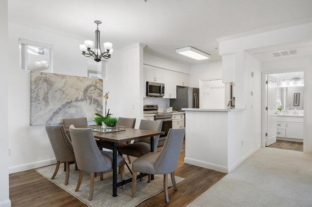 dining area with a notable chandelier, crown molding, and dark hardwood / wood-style floors