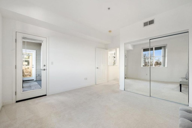 unfurnished bedroom with light carpet and a closet