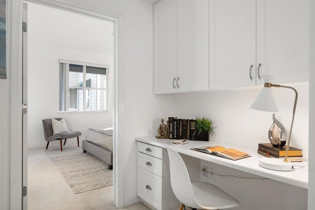 office area featuring built in desk and light colored carpet