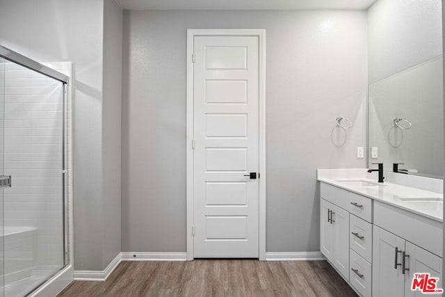 bathroom with vanity, hardwood / wood-style flooring, and a shower with shower door