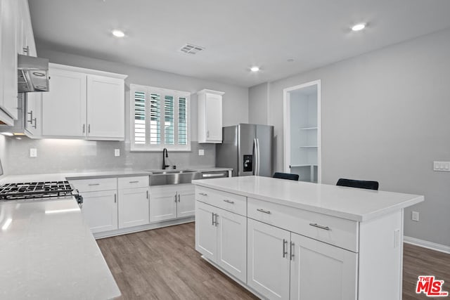 kitchen with sink, white cabinetry, a center island, stainless steel fridge with ice dispenser, and stove