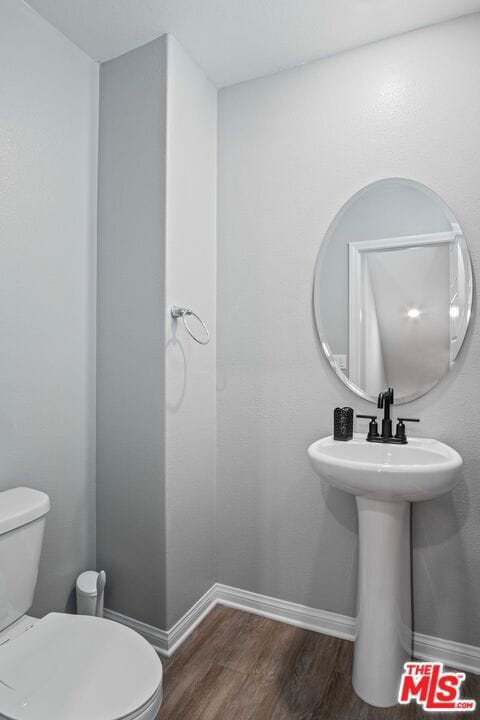 bathroom featuring wood-type flooring and toilet