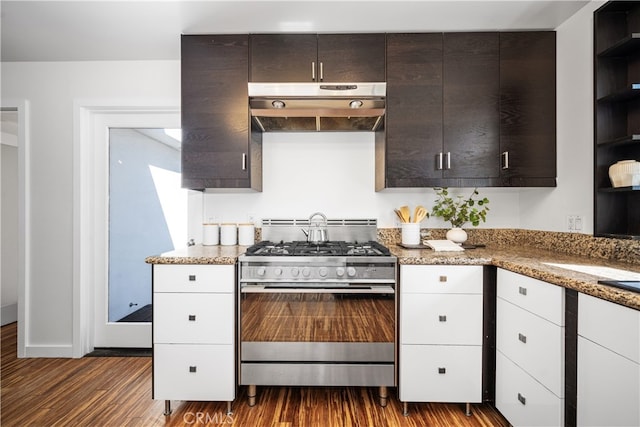 kitchen with light stone counters, dark brown cabinets, under cabinet range hood, open shelves, and gas stove