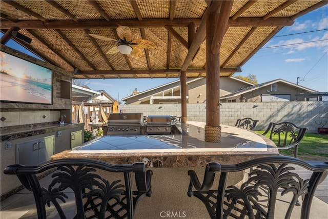 view of patio / terrace with area for grilling, ceiling fan, an outdoor kitchen, and outdoor wet bar