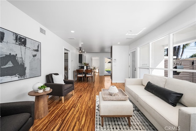 living room featuring visible vents and wood finished floors